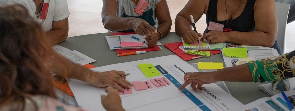 bras et mains qui tiennent des post its étalés sur une table